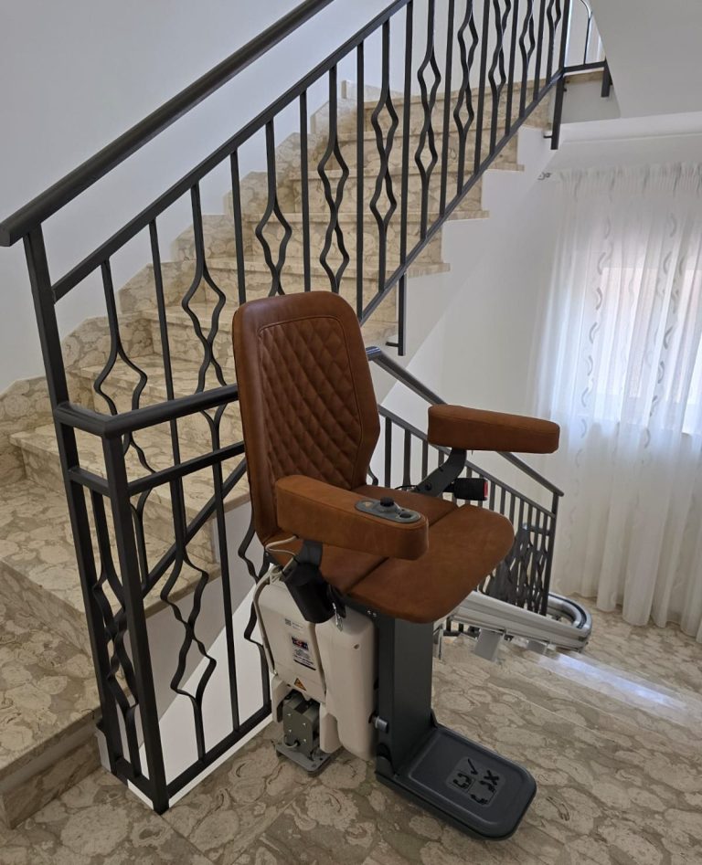 Treppenlift mit braunem Sitz an einer Treppe, leichte Wandverkleidung im Hintergrund in Warendorf Treppenlift mit braunem Sitz an einer Treppe, leichte Wandverkleidung im Hintergrund in Warendorf